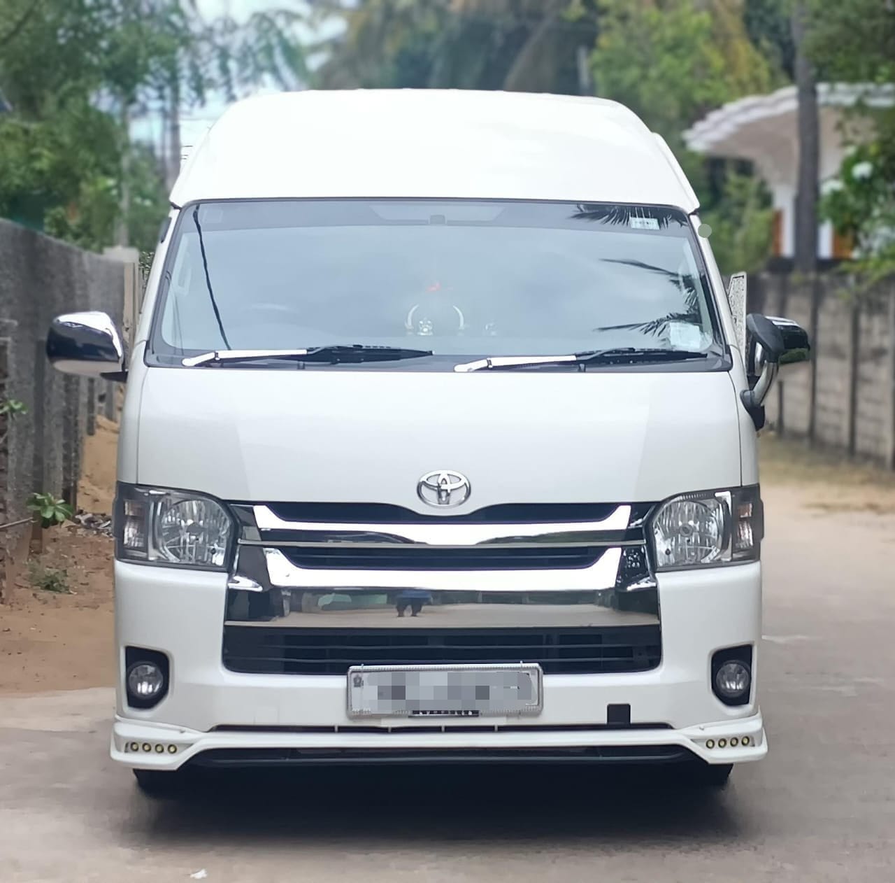 White high-roof Toyota van viewed from the front